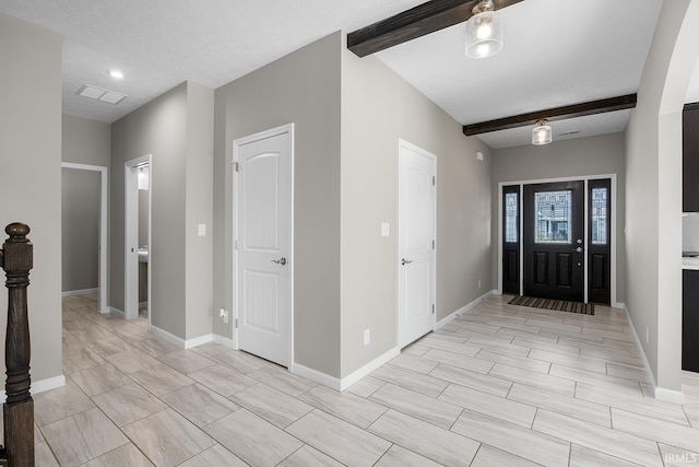 entryway with a textured ceiling and beam ceiling