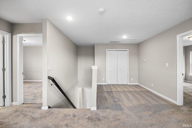 corridor with carpet and a textured ceiling