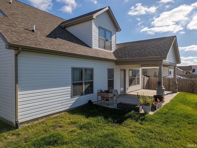 back of property with a lawn and a patio