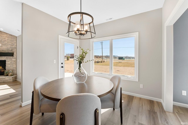 11903 Cross Winds Way, Fort Wayne, IN 46818 - dining space with a chandelier, light wood-style flooring, and a fireplace