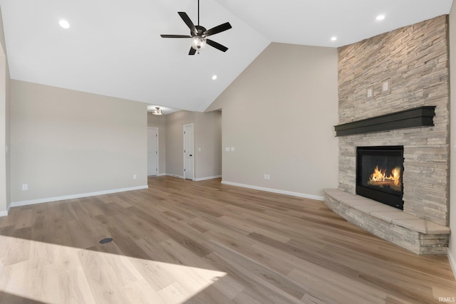 unfurnished living room featuring light hardwood / wood-style flooring, a fireplace, high vaulted ceiling, and ceiling fan