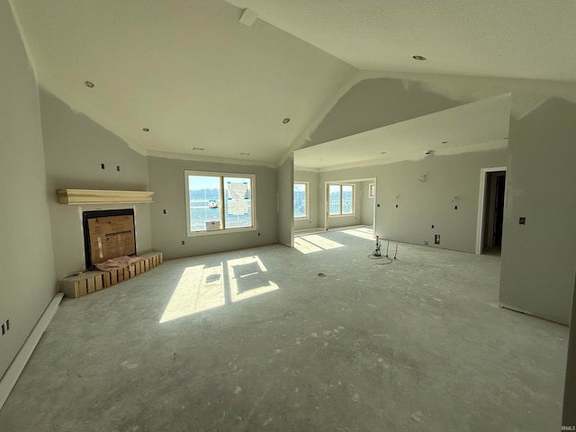 unfurnished living room with a brick fireplace and high vaulted ceiling