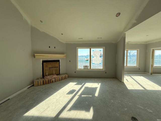 unfurnished living room featuring vaulted ceiling and ornamental molding