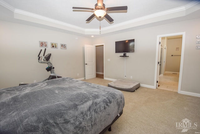 bedroom with ornamental molding, a tray ceiling, light colored carpet, and ceiling fan