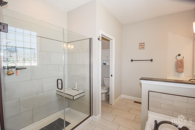 bathroom with tile patterned flooring, toilet, and an enclosed shower