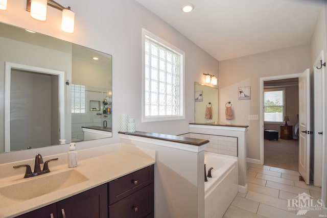 bathroom featuring tile patterned flooring, vanity, and shower with separate bathtub