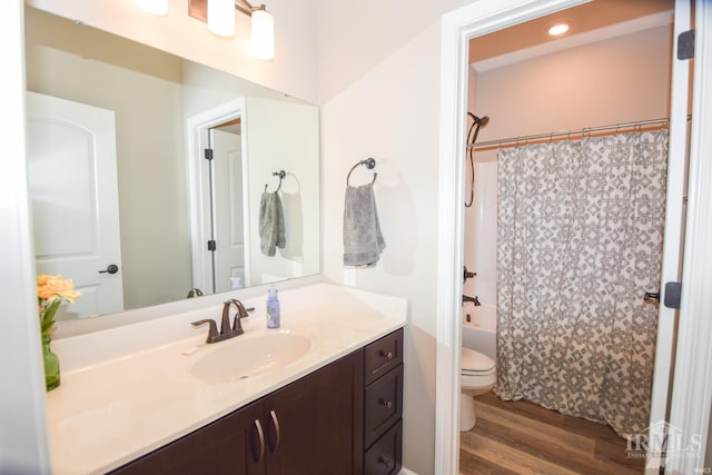 full bathroom with shower / bathtub combination with curtain, wood-type flooring, toilet, and vanity