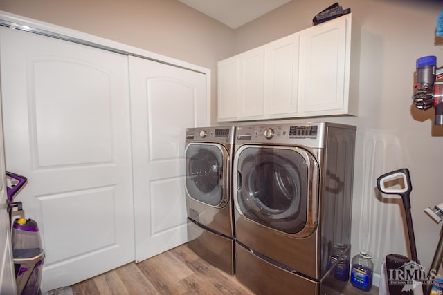 clothes washing area with light hardwood / wood-style floors, cabinets, and washer and clothes dryer