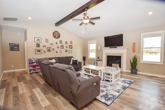 living room with light wood-type flooring, vaulted ceiling with beams, and ceiling fan