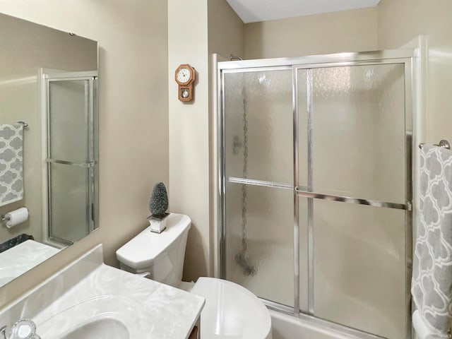 bathroom with a shower with door, vanity, and toilet