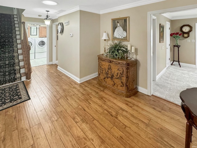 foyer with ornamental molding, light hardwood / wood-style flooring, and washer and dryer