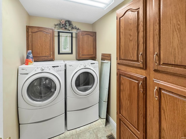 laundry room featuring cabinets and washing machine and clothes dryer