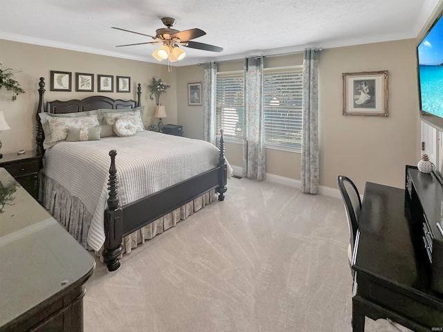 bedroom with ornamental molding, a textured ceiling, light carpet, and ceiling fan