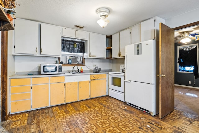 kitchen featuring dark hardwood / wood-style flooring, sink, white cabinets, white appliances, and ceiling fan