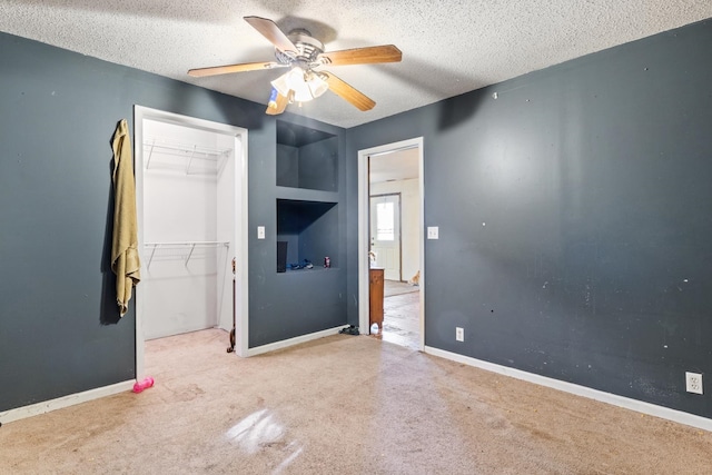 unfurnished bedroom with ceiling fan, a textured ceiling, a closet, and carpet floors