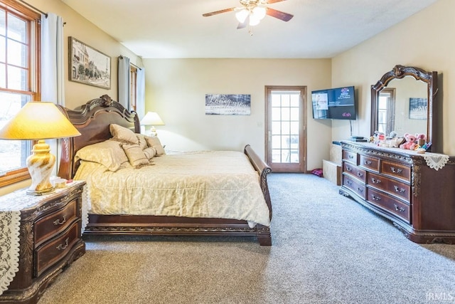 carpeted bedroom featuring multiple windows and ceiling fan