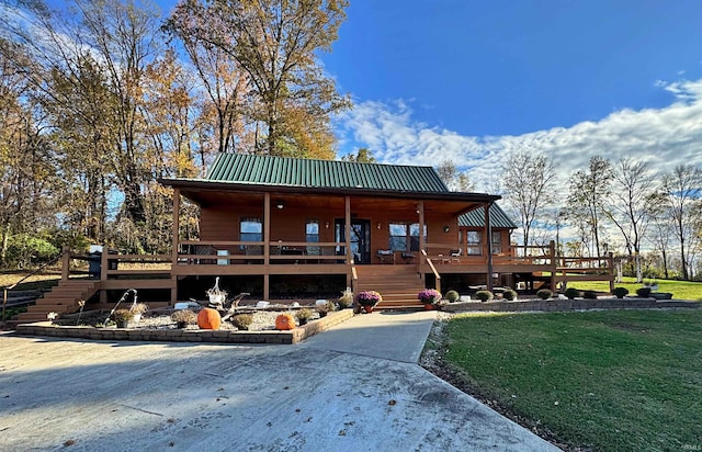 view of front of home with a front yard and a wooden deck