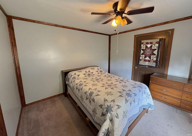 carpeted bedroom featuring ceiling fan and crown molding