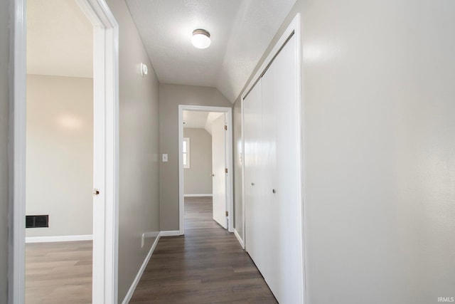 hallway featuring dark wood-type flooring and a textured ceiling