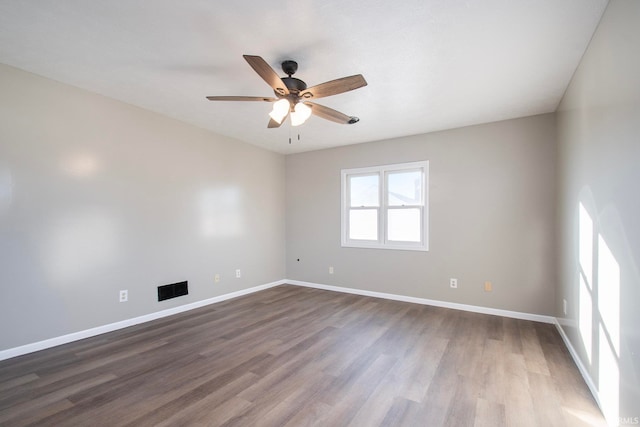 spare room featuring ceiling fan and dark hardwood / wood-style flooring