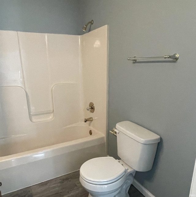 bathroom with hardwood / wood-style floors, shower / washtub combination, and toilet