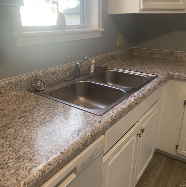 kitchen with dark wood-type flooring, white dishwasher, white cabinets, and sink