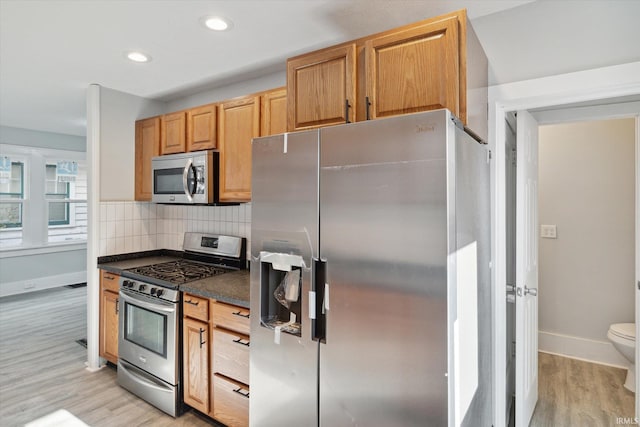 kitchen featuring light wood-type flooring, backsplash, and stainless steel appliances