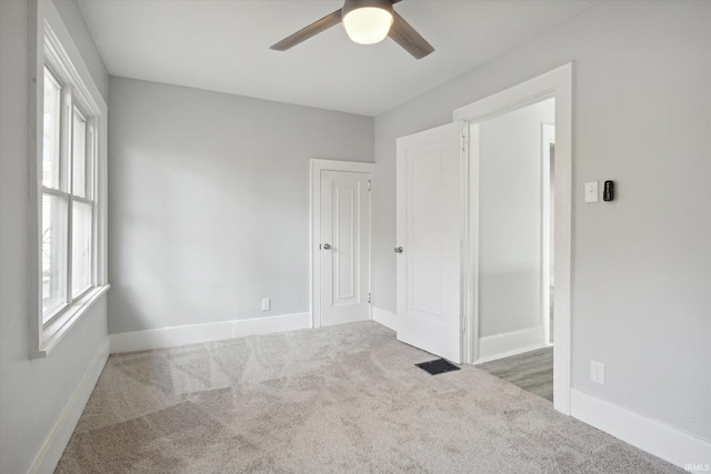 unfurnished room featuring ceiling fan and dark carpet