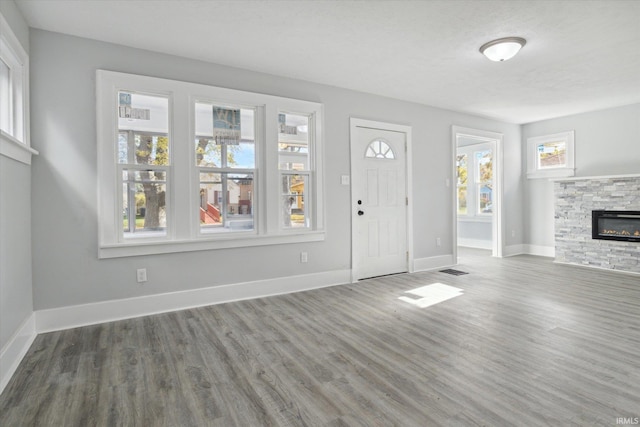 unfurnished living room with a fireplace, dark wood-type flooring, and a textured ceiling