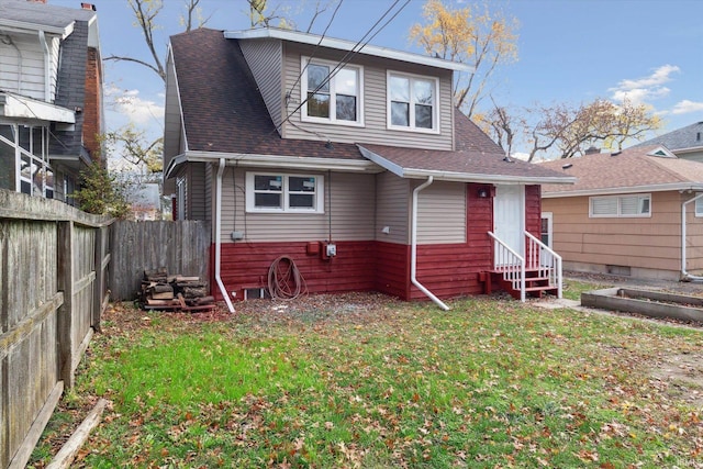 rear view of house featuring a yard