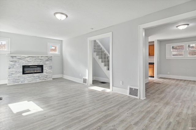 unfurnished living room with a fireplace and light wood-type flooring