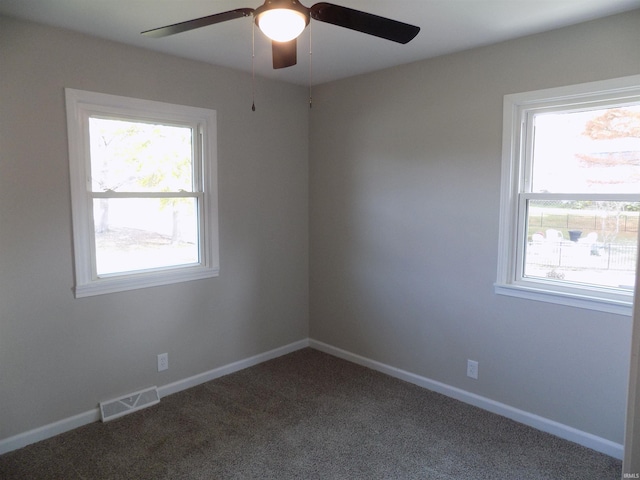 spare room with ceiling fan, plenty of natural light, and carpet flooring