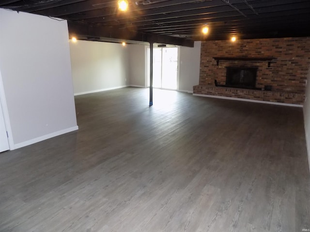 basement with a fireplace and wood-type flooring