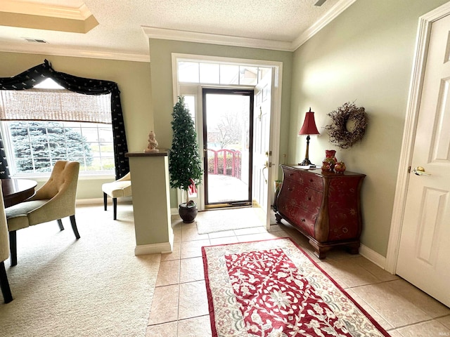 tiled foyer entrance with a textured ceiling and crown molding