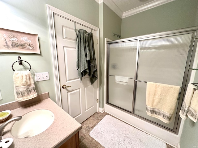 bathroom featuring tile patterned floors, vanity, a shower with door, and crown molding