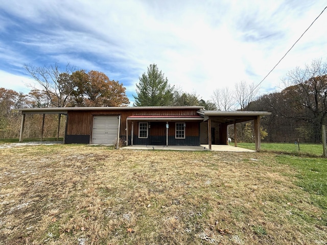 rear view of house featuring a garage, a yard, and a carport