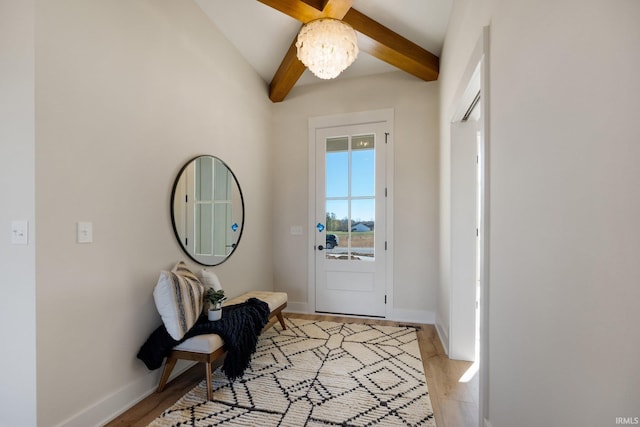 entryway with lofted ceiling with beams and light hardwood / wood-style flooring