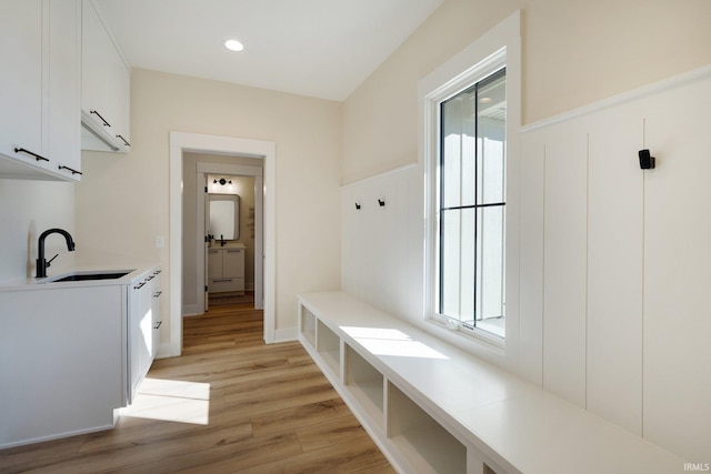 mudroom with sink and light hardwood / wood-style floors