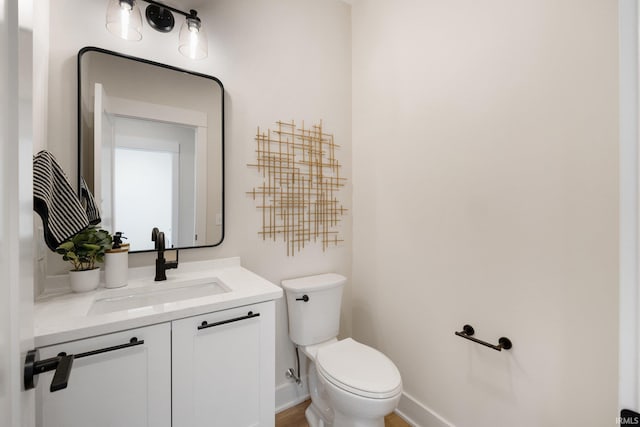 bathroom featuring toilet, vanity, and hardwood / wood-style flooring