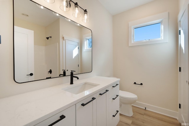 bathroom featuring hardwood / wood-style floors, a healthy amount of sunlight, toilet, and vanity