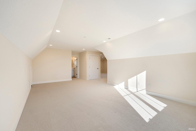 additional living space featuring lofted ceiling and light colored carpet