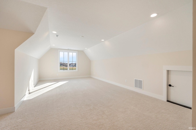 bonus room with light colored carpet and lofted ceiling