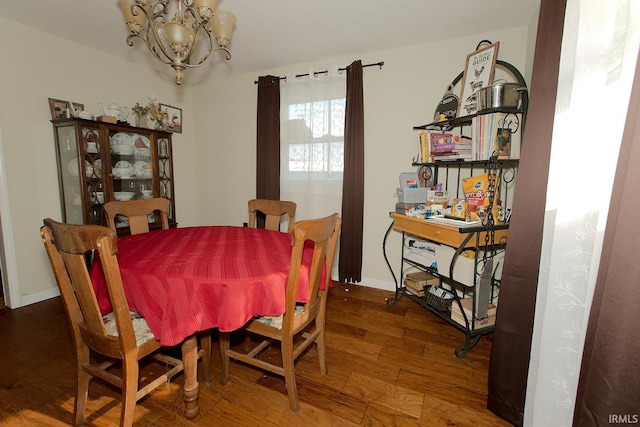 dining room with hardwood / wood-style floors and a chandelier