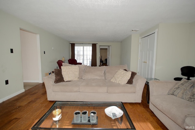 living room with a textured ceiling and light hardwood / wood-style flooring