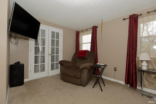 sitting room with french doors and light carpet