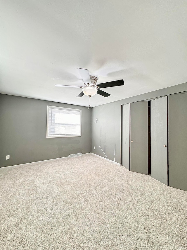 interior space with carpet floors and ceiling fan