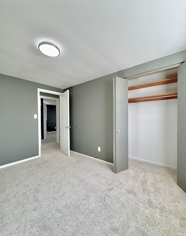 unfurnished bedroom featuring light colored carpet and a closet