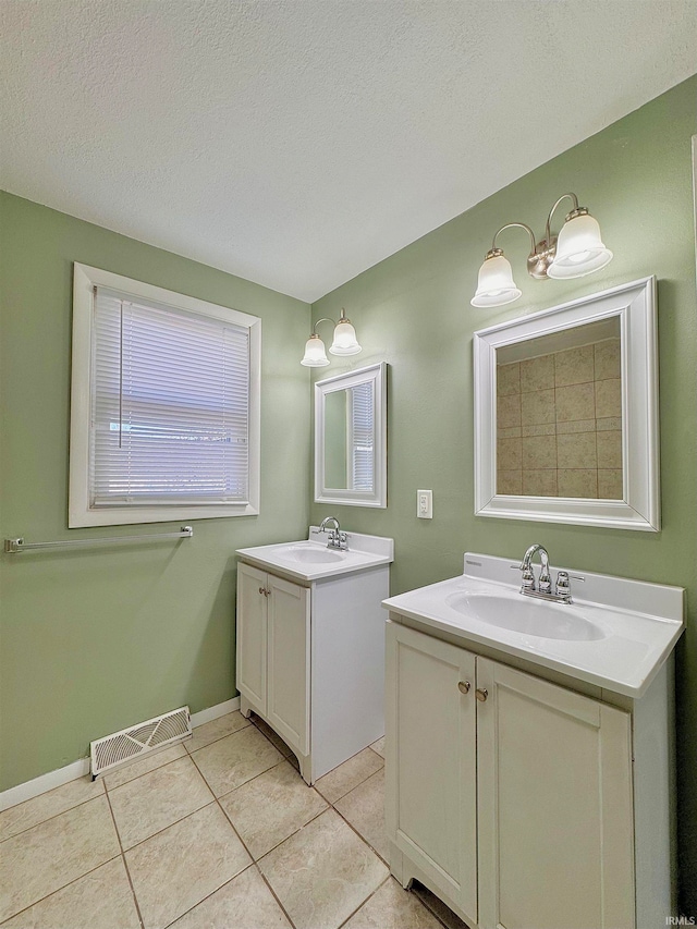 bathroom with vanity, a textured ceiling, and tile patterned floors