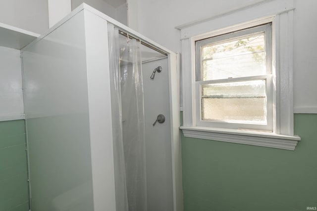 bathroom featuring a shower with shower door