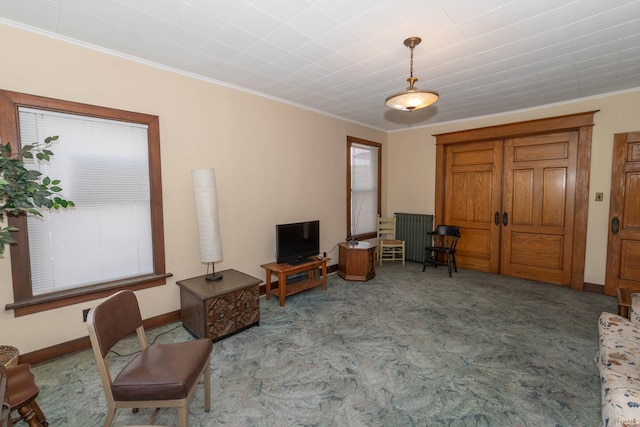 sitting room with a healthy amount of sunlight, light carpet, and ornamental molding